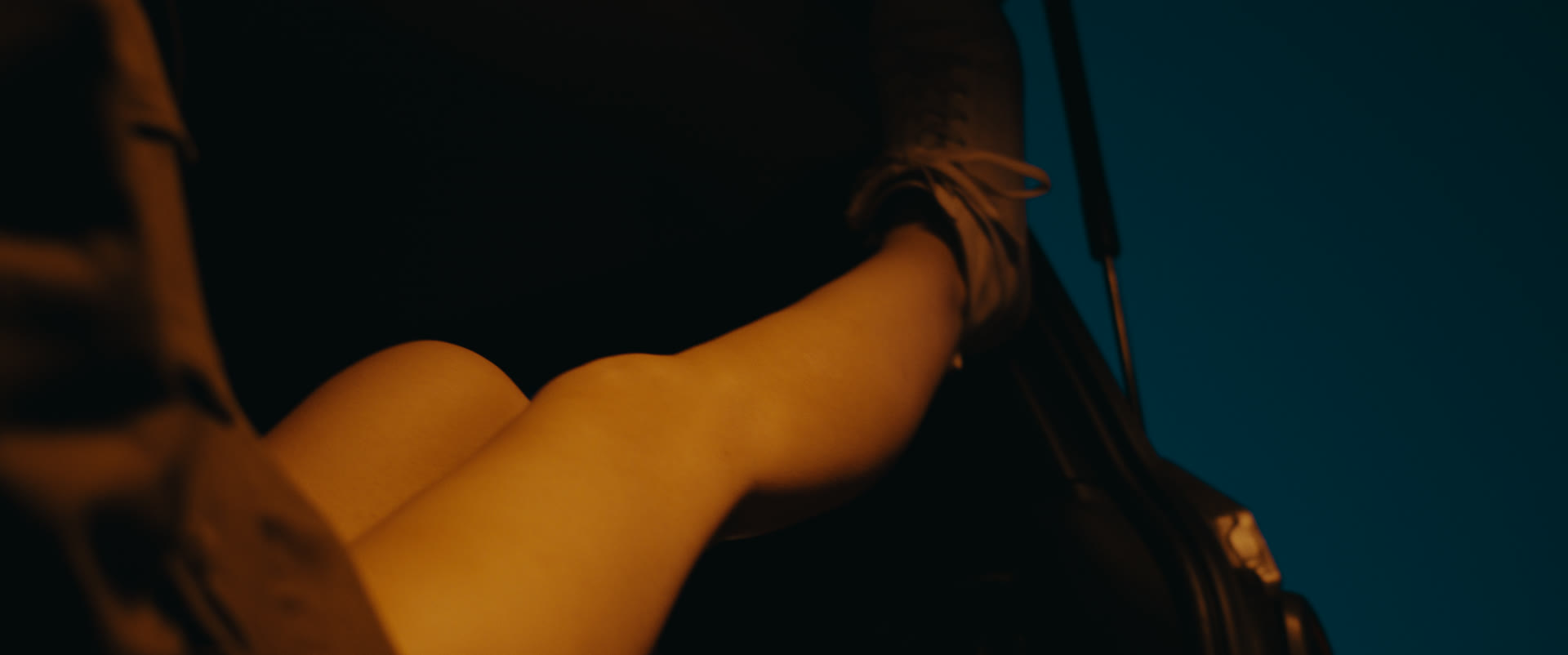 Crossed legs resting in the car trunk at night — still from Memories
